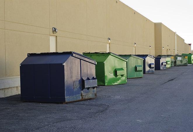 a series of colorful, utilitarian dumpsters deployed in a construction site in Moira, NY